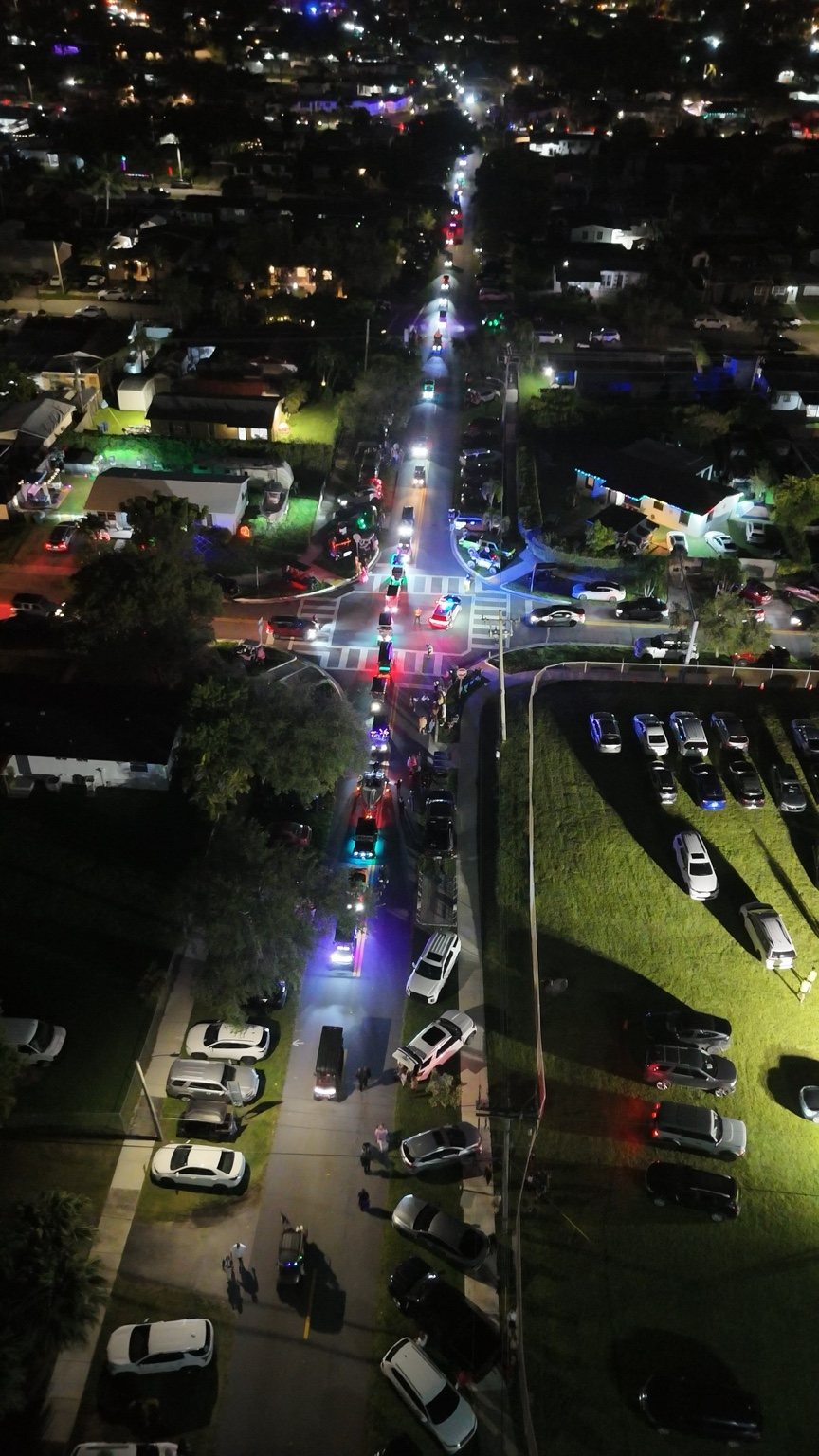Aerial view of a neighborhood golf cart parade at night